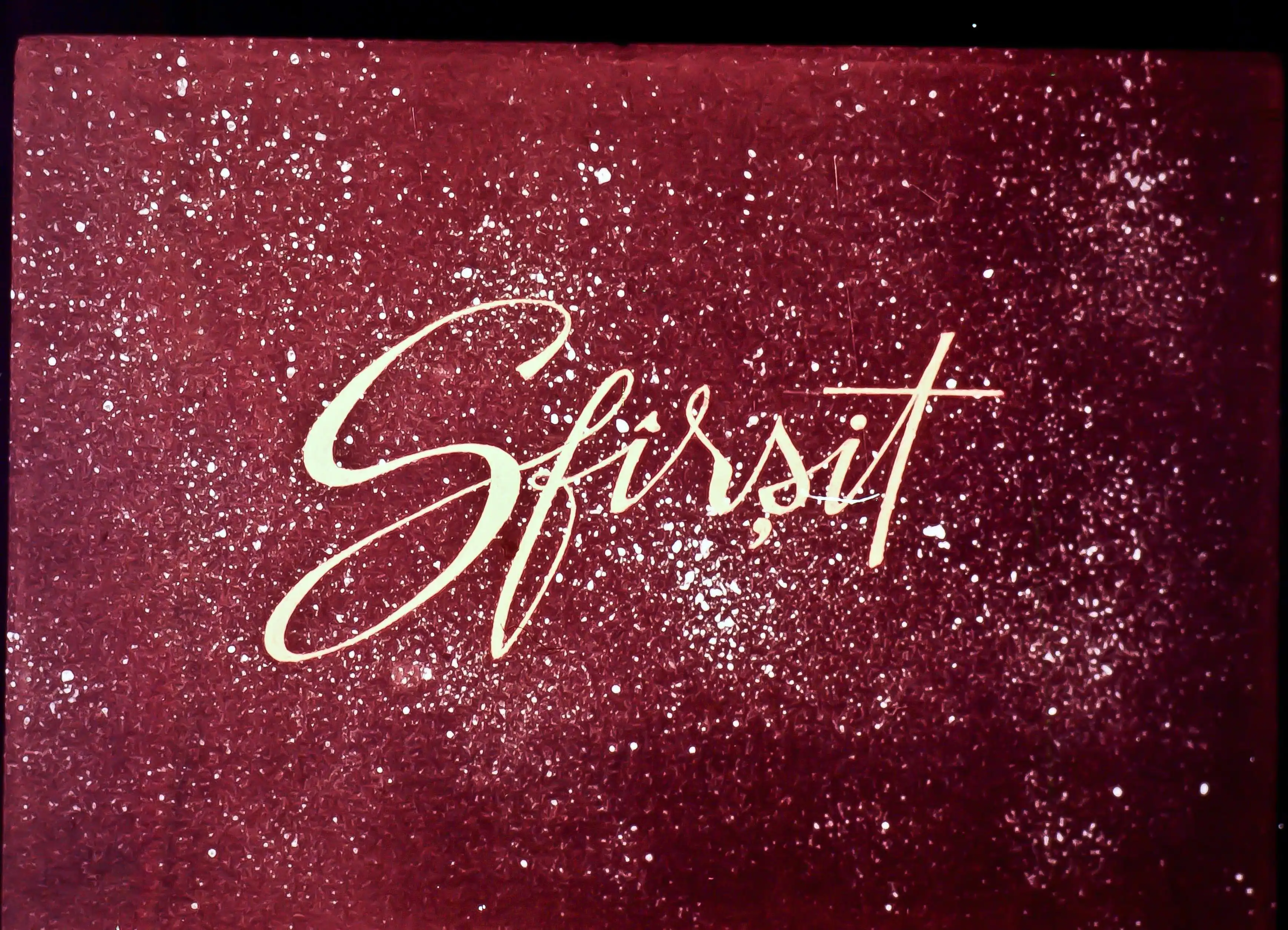 Text stilizat pe fundal roșu cu efecte strălucitoare, cuvântul 'Sfîrsit' este scris într-un font elegant.